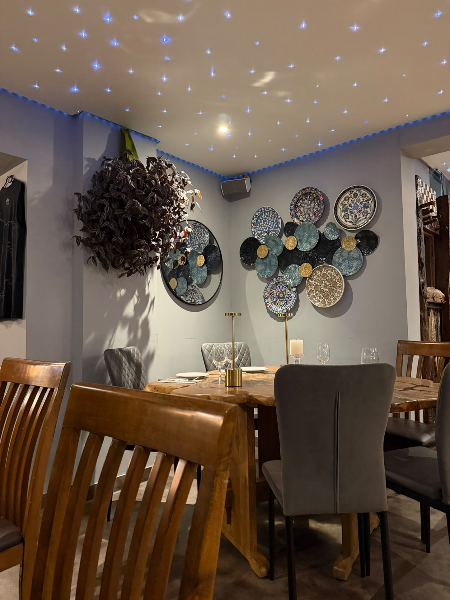 Gedeckter Tisch mit handbemalten Keramikteller an der Wand im Trüffel Modern Mediterranean Restaurant